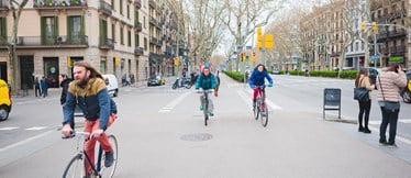 Cyklister åker på en bred gata i centrala Barcelona.