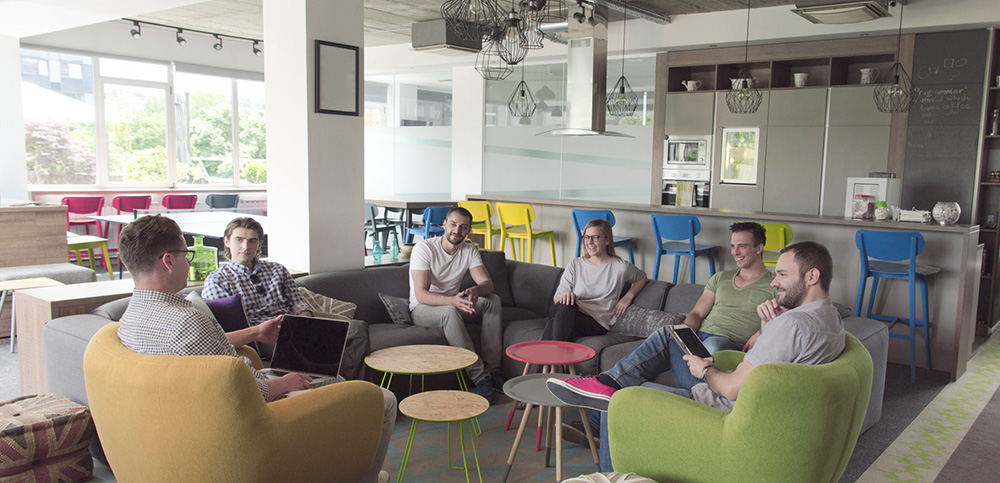 Möbler i kontorslandskap med arbetsgrupp som brainstormar