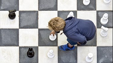 Barn flyttar stora schackpjäser