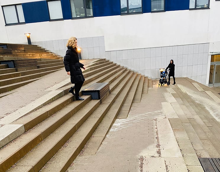 Personer går i trappa med universell utformning.