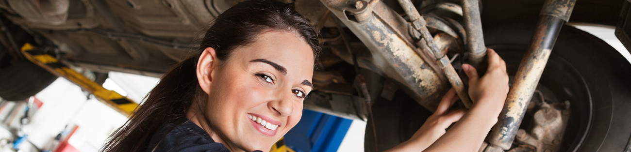 En ung tjej arbetar med att reparera en motor.